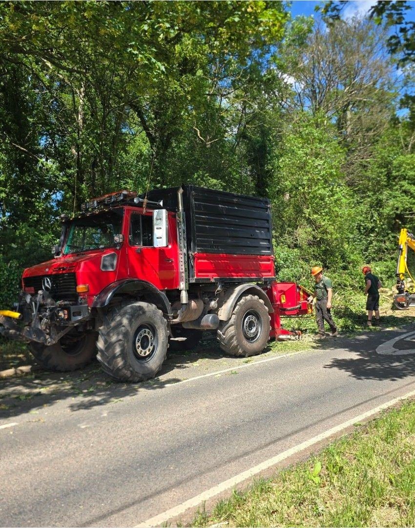 HB Forestry's red Unimog and chipper on roadside tree works